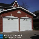 Overhead garage doors replacement in Toronto features pair of two raised panel doors in white