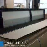 Showcasing panel of glass garage door to be installed by smart doors at concord