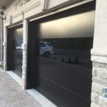 Modern matt black garage door with glossy glass insert installed